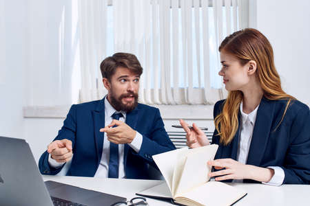 colleagues sitting at a desk in front of a laptop officialsの写真素材