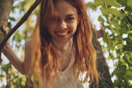 red-haired woman in the forest near the tree nature summerの写真素材
