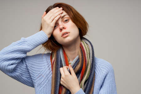 sick woman neck scarf cold handkerchief light backgroundの写真素材