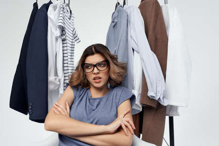 woman with glasses clothes hanger shopping light backgroundの写真素材