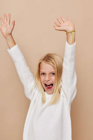 Little cute girl in a sweater, grimaces kids lifestyle concept