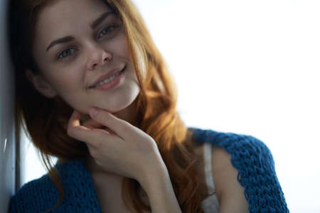 pretty woman sitting near the window with a blue plaidの写真素材