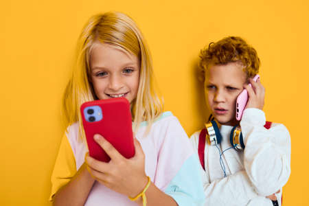 Photo of two small kids girl looking at the phone entertainment communication isolated backgroundの写真素材