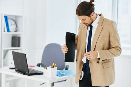 man in beige jacket in the office with documents lifestyle