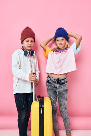 cute smiling kids stylish clothes suitcase headphones studio posing