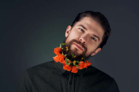 bearded man with flowers in a beard In a shirt dark backgroundの写真素材