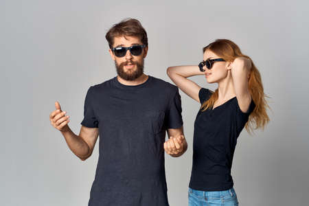 fashionable man and woman in black t-shirt sunglasses posing isolated backgroundの写真素材