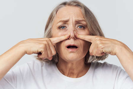 elderly woman runny nose handkerchief cold