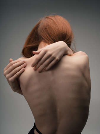 naked back women red hair posing studioの写真素材