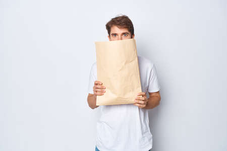 bearded man with craft package in hands shopping emotions light backgroundの写真素材