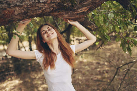 pretty woman near a tree outdoors in the forest fresh air and travelの写真素材