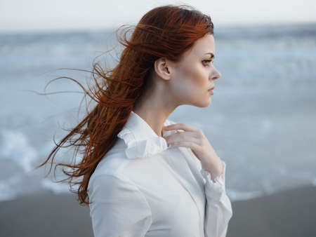 pretty red-haired woman in white dress lifestyle fresh air fashion travelの写真素材