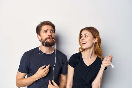 young couple playing with headset on grey background.
