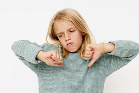 little girl with funny expression and thumbs down.