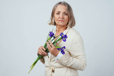 elderly woman with a bouquet of flowers gift caring birthdayの写真素材