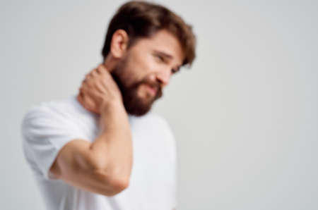 man in a white t-shirt stress medicine pain in the neck isolated backgroundの写真素材