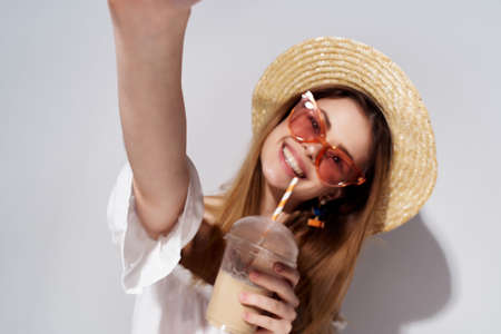 beautiful woman a glass with a drink in hand fashion light backgroundの写真素材