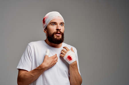 bearded man in a white t-shirt trauma health diagnosis light backgroundの写真素材