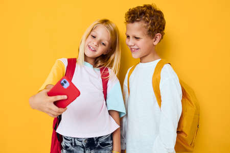 Photo of two small kids girl phone selfie grimace fun Studio education conceptの写真素材