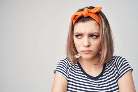 woman in striped t-shirt studio posing orange bandageの写真素材