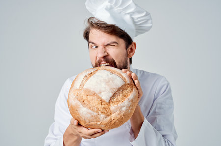bearded man chef with bread in hand Professional emotionsの写真素材