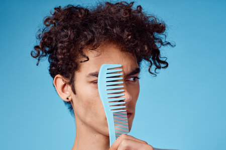 curly guy with a comb hair lifestyle blue backgroundの写真素材