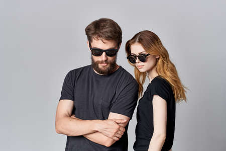 a young couple in black t-shirt sunglasses posing isolated backgroundの写真素材