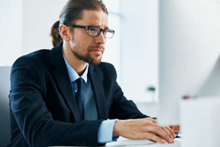 business man in a suit with glasses in the office at his desk