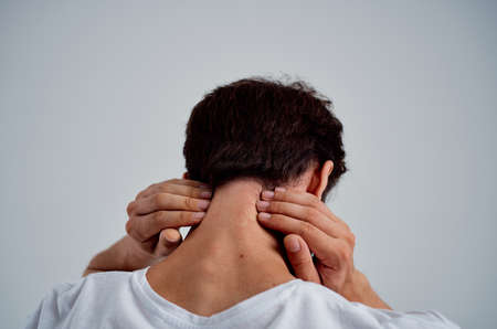 bearded man in a white t-shirt stress medicine pain in the neck light backgroundの写真素材