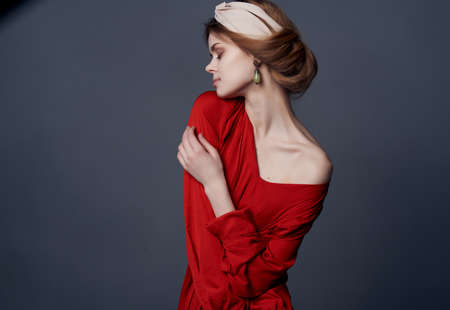 woman in red dress decoration posing luxury dark backgroundの写真素材