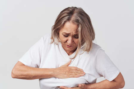elderly woman in white t-shirt health problems treatment dissatisfactionの写真素材