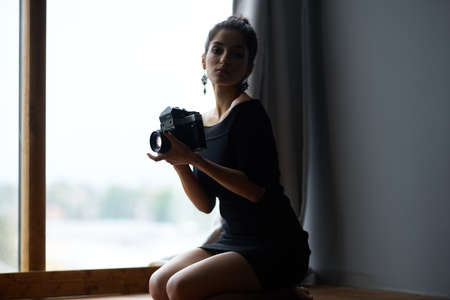 beautiful woman near window posing attractive look earrings lifestyle studioの写真素材