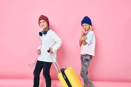 adorable little kids with a yellow suitcase in his hands Childhood lifestyle concept