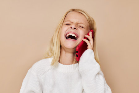 Little cute girl red phone in hand cropped viewの写真素材