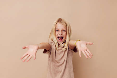 happy cute girl in a beige t-shirt isolated backgroundの写真素材