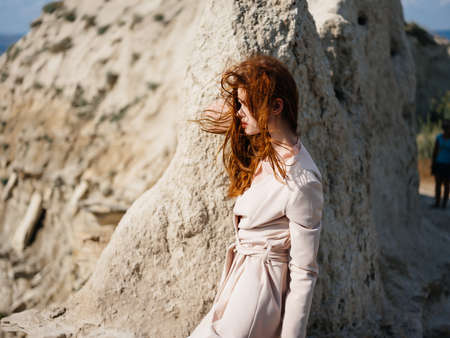 pretty woman posing near rocks in the sand attractive lookの写真素材