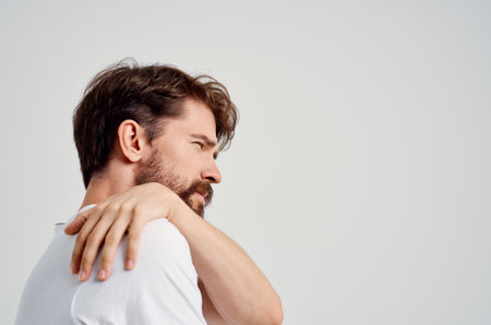 emotional man in a white t-shirt stress medicine pain in the neck studio treatmentの写真素材