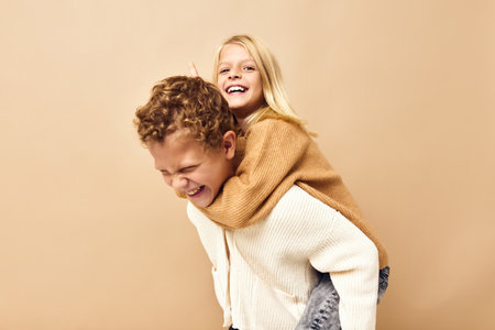 boy and girl fun fashion youth stylish-clothing childhood beige backgroundの写真素材