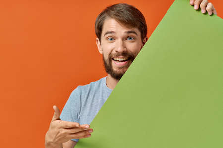 emotional man holding a green banner design orange background