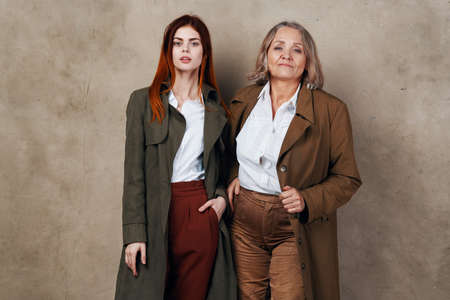 young and old woman are standing next to each other in a coat posingの写真素材