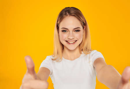 cheerful woman in a white t-shirt hand gesture isolated backgroundの写真素材