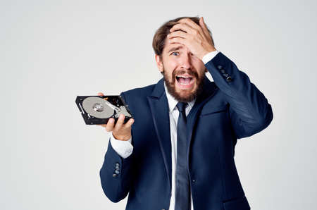 emotional business man with hard drive on computer technologyの写真素材