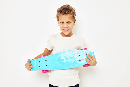 adorable stylish boy curly hair with skateboard light background