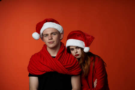 family in santa hats fun new year holiday red backgroundの写真素材