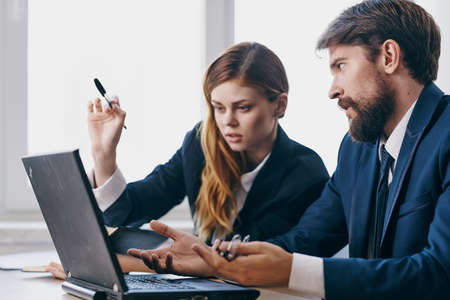 colleagues sitting at a desk with a laptop communication professionals