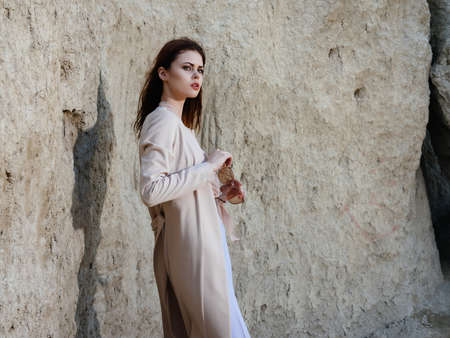 beautiful woman posing near rocks in the sand elegant styleの写真素材