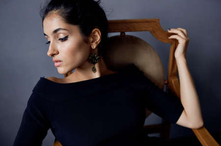 brunette in a black dress near the chair luxury fashion lifestyle studioの写真素材