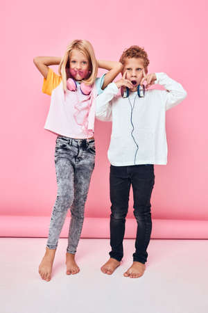 children wearing stylish clothes posing full length headphones