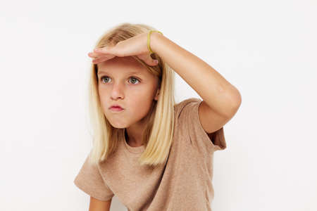 Beautiful little girl gestures with his hands posing studioの写真素材