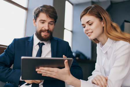 man and woman in business suits looking at the tablet managers professionalsの写真素材